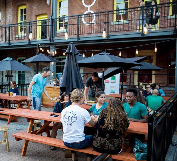 Folks enjoying beer on the patio at Whistle Buoy Brewing in Victoria, BC