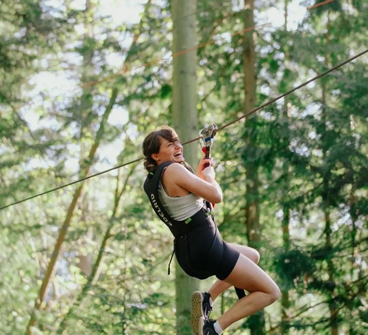 A woman glides through the trees at WildPlay Elements Park in Victoria, BC