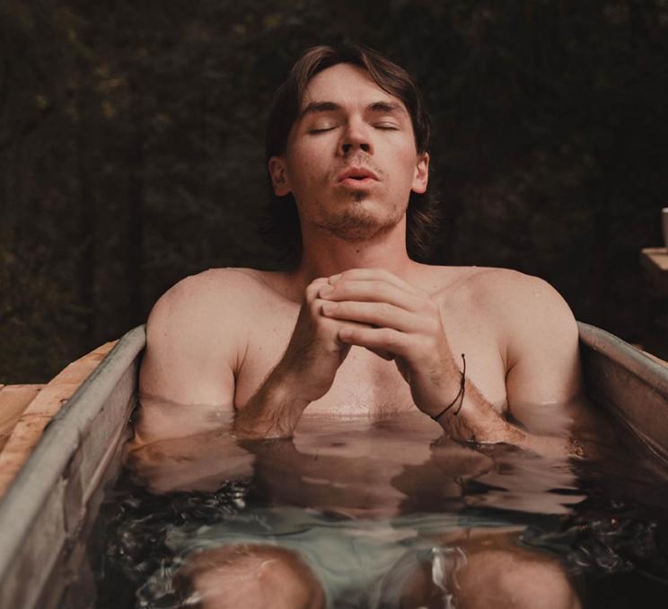 A man soaks in a cold plunge at Wildwood Saunas in Victoria, BC