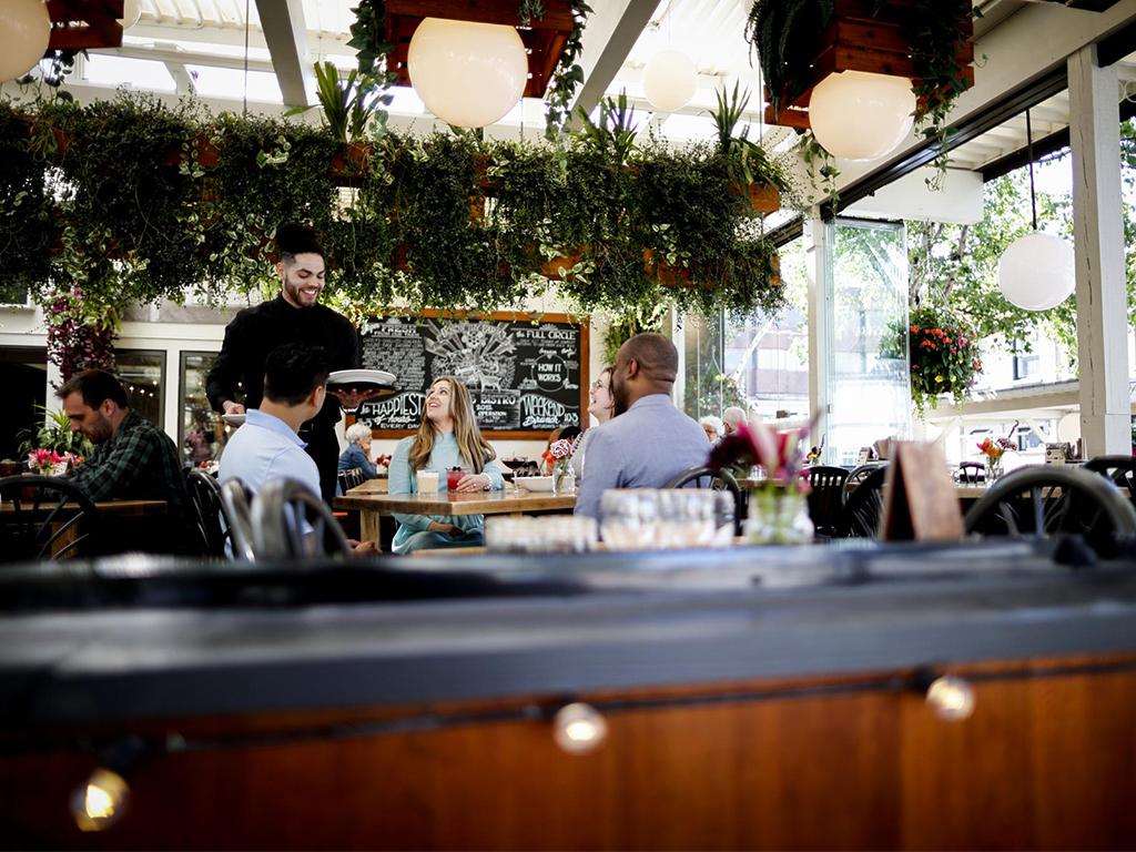 A group dines at 10 Acres Bistro in Victoria, BC