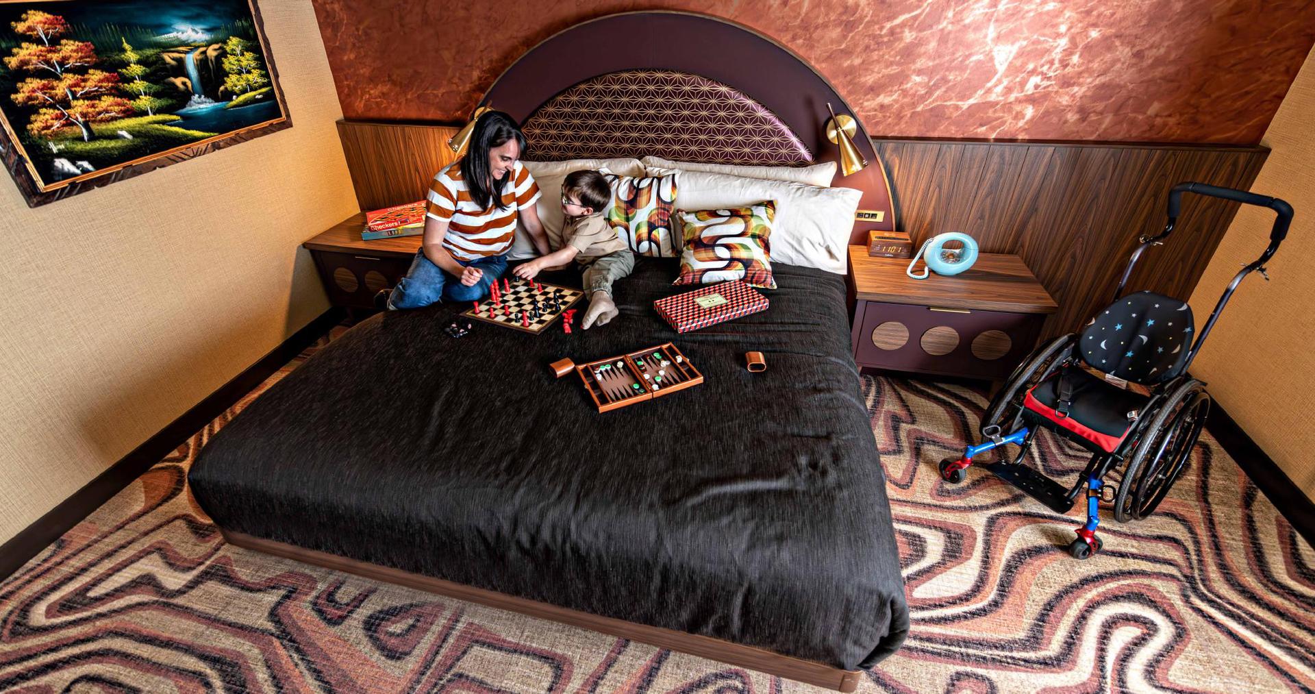 A mother and son play games on a bed at Hotel Zed in Victoria, BC