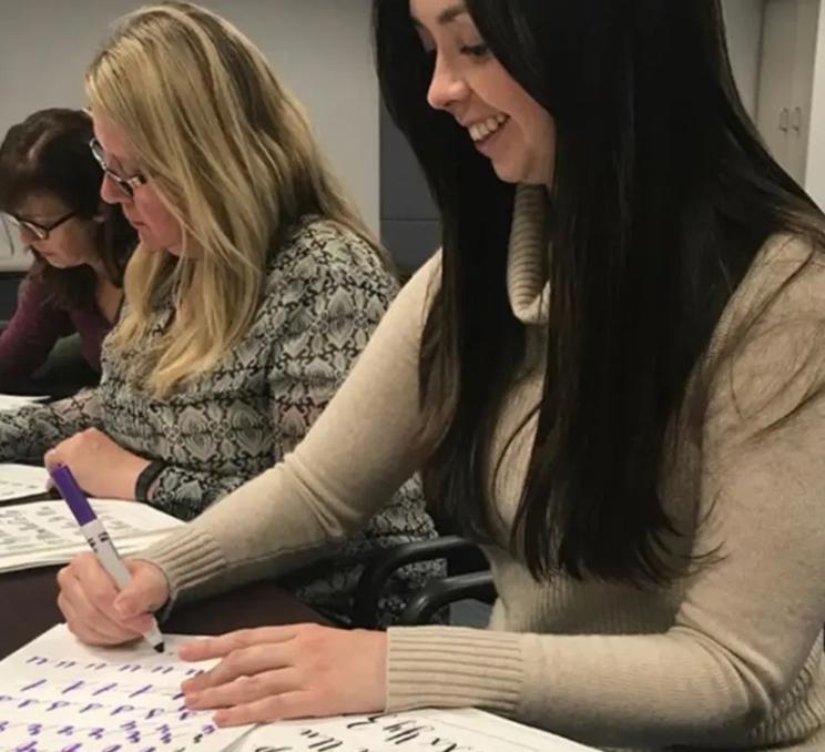 A group enjoys a calligraphy lesson in Victoria, BC