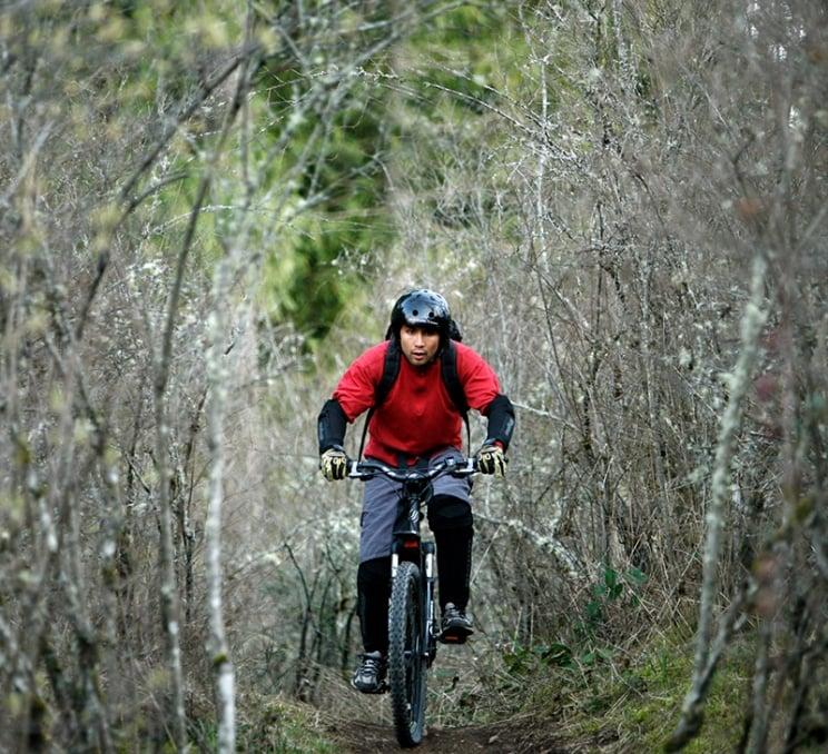 A cyclist tides through the forest at Mount Work Regional Park in Victoria, BC