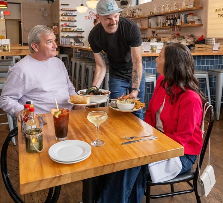 A couple is served lunch at Shuck Taylor's in Victoria, BC