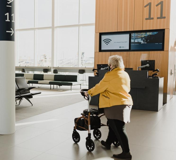 A woman walks through YYJ airport in Victoria, BC