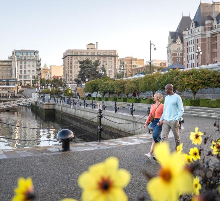 A couple walks along the lower causeway of the Inner Harbour in Victoria, BC