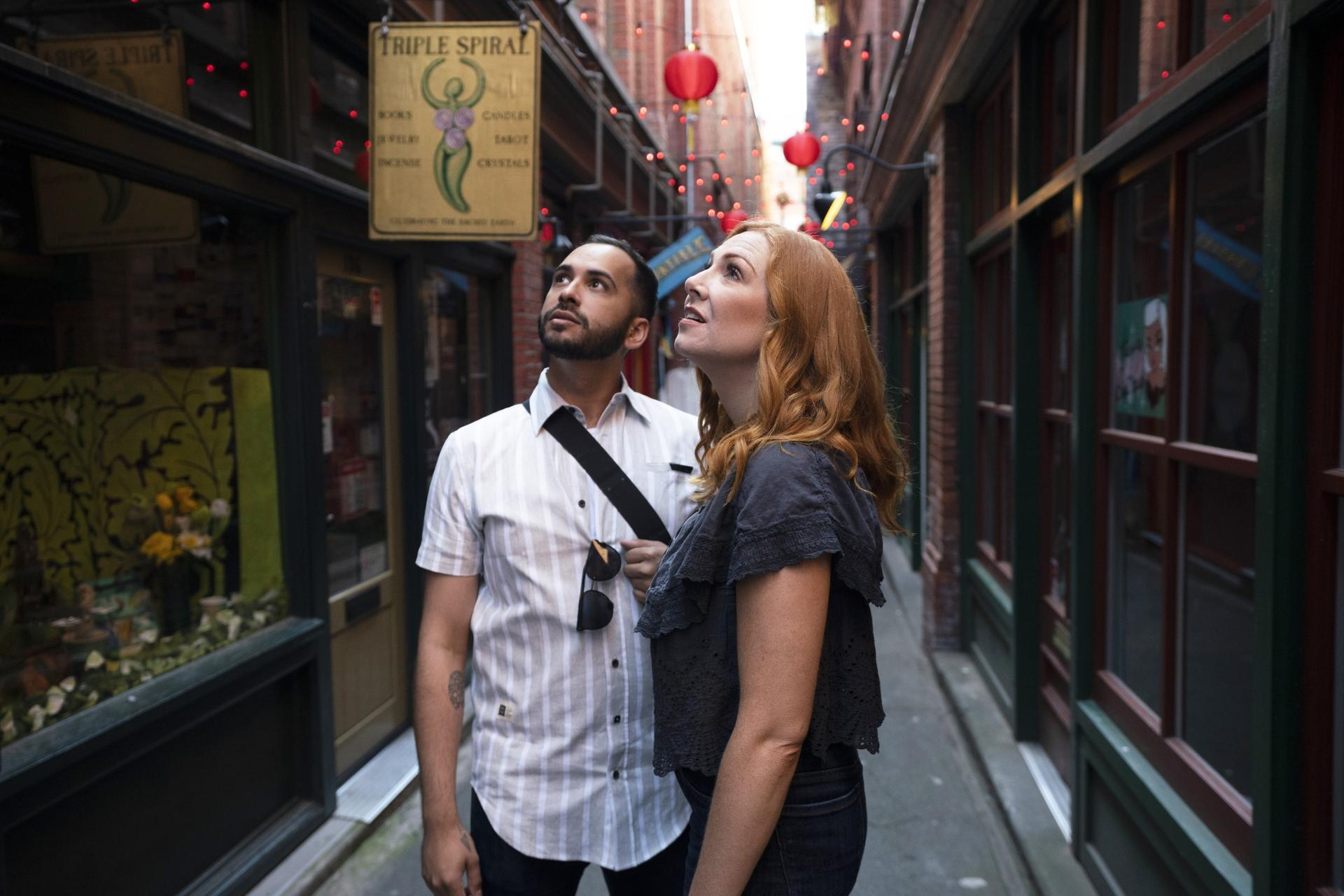 A couple explores Fan Tan Alley. Canada's narrowest street, in Victoria, BC