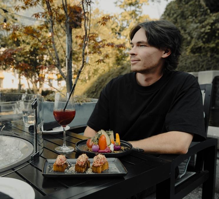 A man dines on the patio at Fathom at the Hotel Grand Pacific in Victoria, BC