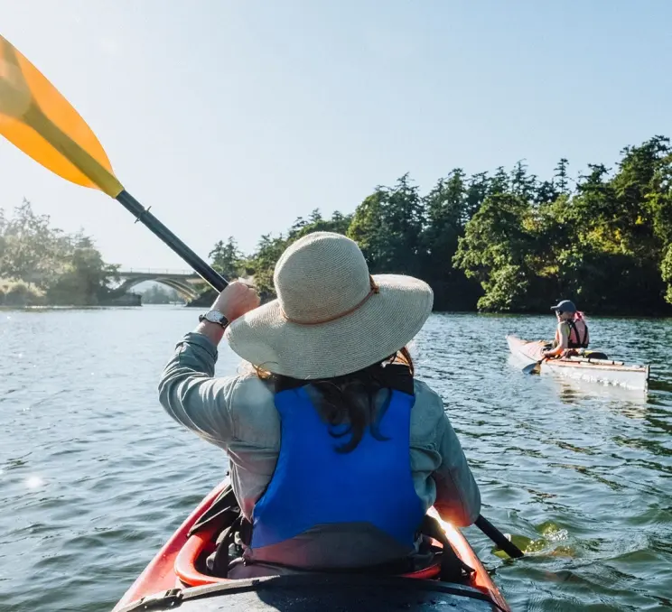 A woman kayaks along the Gorge Waterway in Victoria, BC