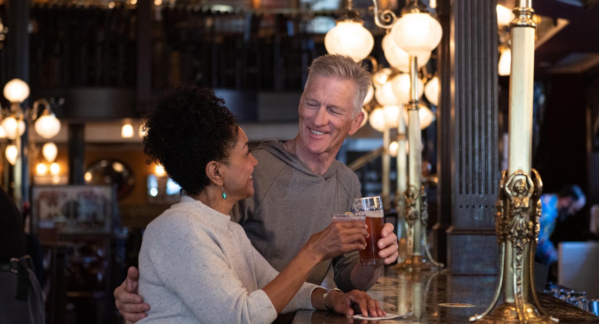 A couple enjoying a drink at the bar at the Bard & Banker in Victoria, BC