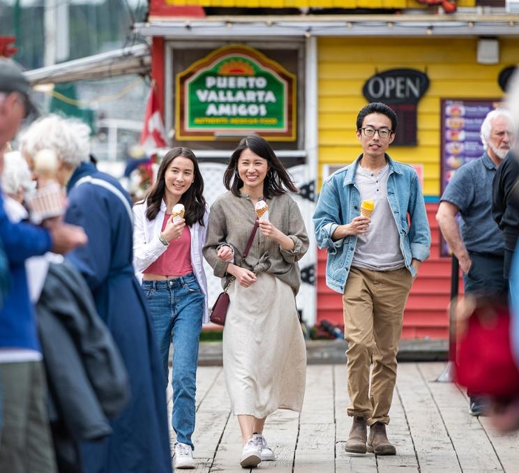 A young family enjoys ice cream while out for a walk along Fisherman's Wharf in Victoria, BC