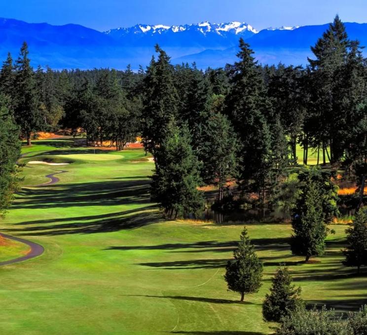 A view along the fairway at Olympic View Golf Course with the Olympic Mountains in the background in Victoria, BC